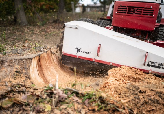 Stump grinder attachment clearing a freshly cut tree stump